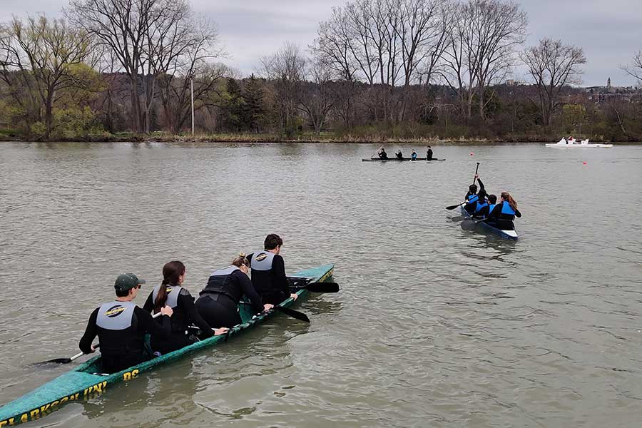 Students testing the concrete canoes on the water