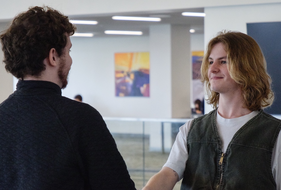 Two young men shaking hands.