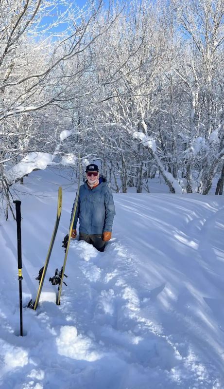 Male student knee deep in snow.